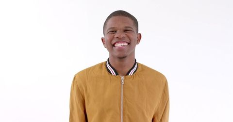 Young Man in Mustard Jacket Laughing on White Background