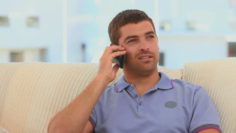 Casual Man Relaxing on Sofa During Phone Call