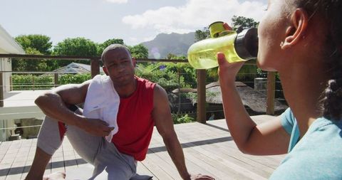 Biracial Couple Resting Outdoors After Workout