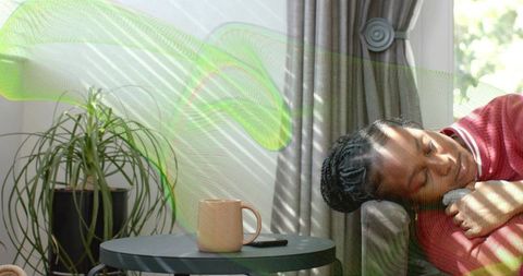 Woman relaxing on sofa in sunny living room with modern decor