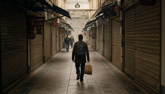 Solitary commuter walking through closed market arcade toward light-filled archway