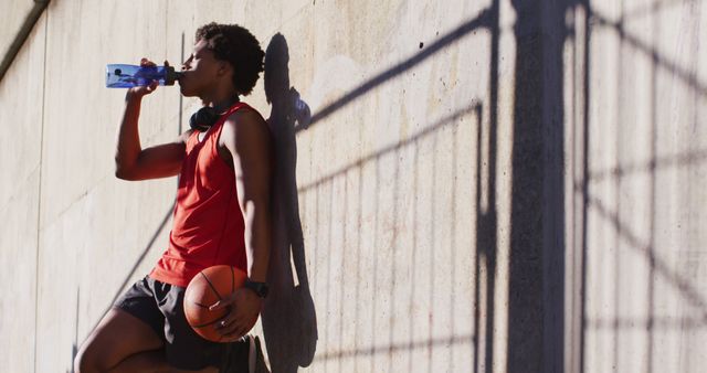 Young Man with Basketball Drinking Water During Outdoor Practice - Download Free Stock Images Pikwizard.com