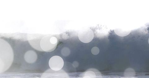 Monumental breaking ocean wave with dramatic foam, spray and soft bokeh overlays