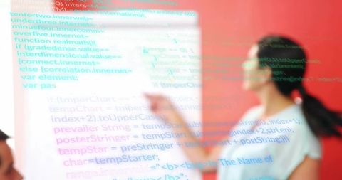 Pointing presenter explaining projected code during interactive coding workshop