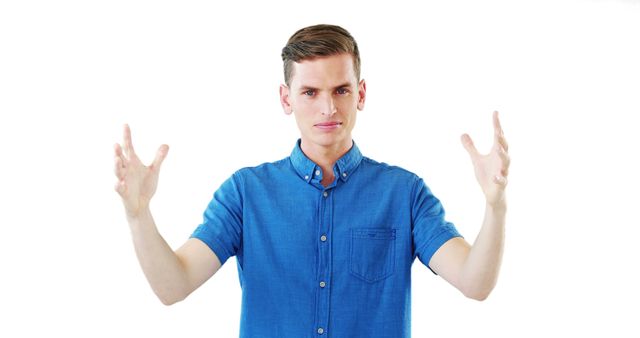 This image shows a confident young man gesturing with open hands bedecked in a blue shirt. Useful for illustrating concepts such as communication, presentation skills, explaining ideas, confidence, and body language. Suitable for business, education, and personal development contexts.