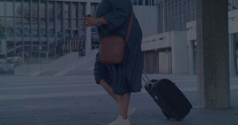 Woman Walking with Suitcase near Modern Building Entrance