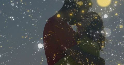Silhouetted couple embracing under golden bokeh lights romantic nighttime kiss intimate