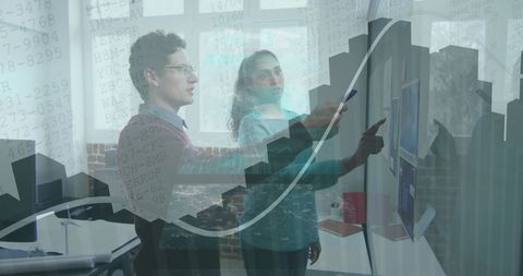 Two Professionals Collaborating on Data Analysis in Modern Office