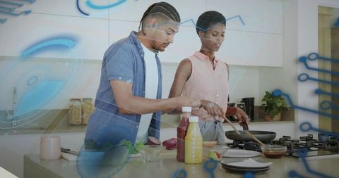 Multicultural couple preparing healthy meal in modern kitchen with smart digital overlay