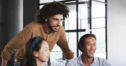 Diverse Colleagues Discussing Work Together in Modern Office