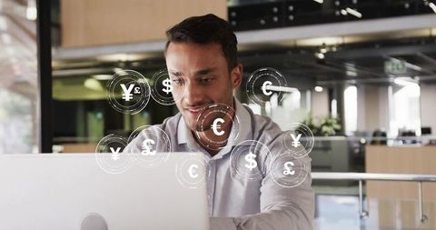 Office professional analyzing global currency trends on laptop
