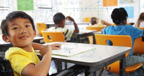 Elementary student concentrating while solving math problems with equation overlay