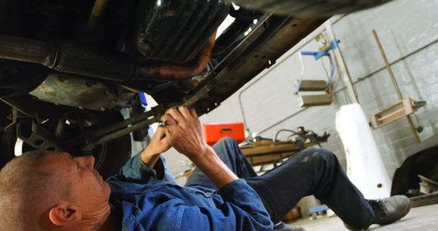 Mechanic Repairing Car Engine Underneath in Workshop - Download Free Stock Images Pikwizard.com