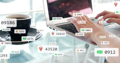 Typing hands on laptop with floating notifications, location pins and alerts on desk