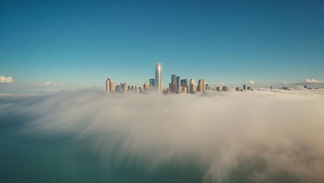 Skyscrapers Piercing Through Foggy Urban Waterfront