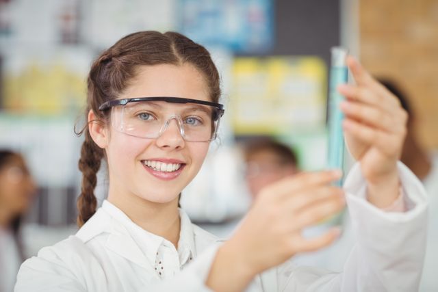Smiling Schoolgirl Conducting Chemistry Experiment in Laboratory - Download Free Stock Photos Pikwizard.com