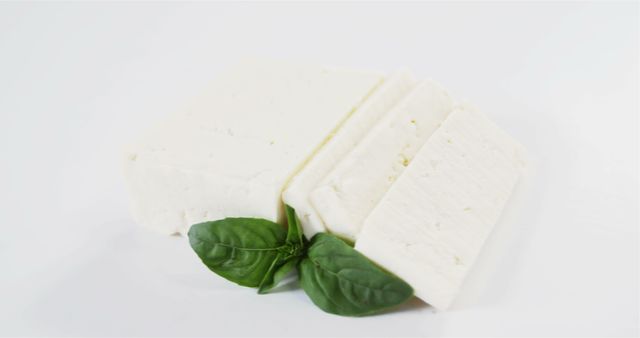 Slices of Fresh White Cheese with Basil Leaves on White Background - Download Free Stock Images Pikwizard.com