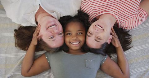 Happy Lesbian Couple with Daughter Smiling Together