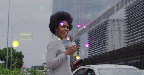 Businesswoman using smartphone overlaid with digital icons in urban setting