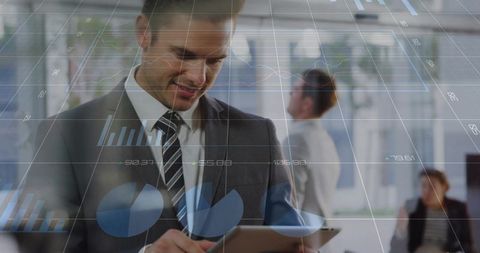 Businessman Holding Tablet Reviewing Interactive Financial Charts in Modern Office Environment