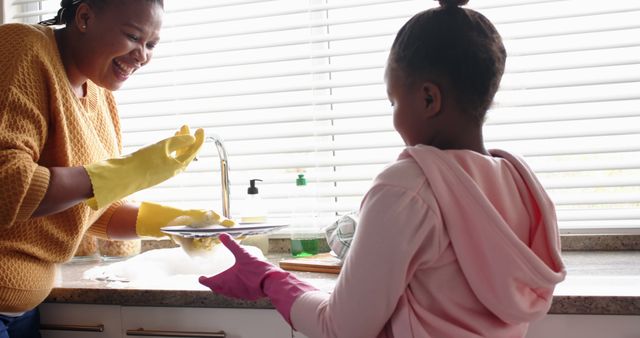 Mother and Daughter Washing Dishes in Kitchen with Smiling Faces - Download Free Stock Images Pikwizard.com