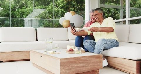 Senior Multiracial Lesbian Couple Celebrating Birthday on Patio