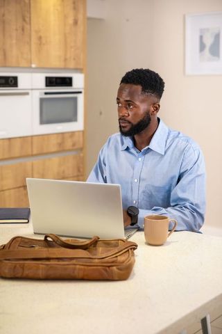 African American Professional Working from Home in Minimalistic Kitchen