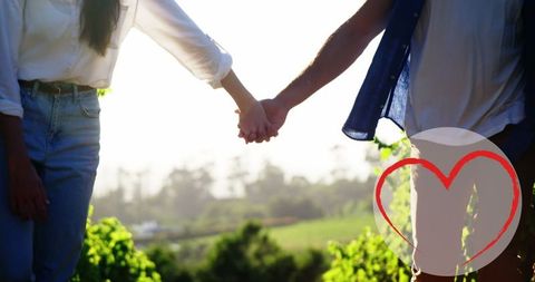 Romantic Caucasian Couple Holding Hands in Sunlit Park
