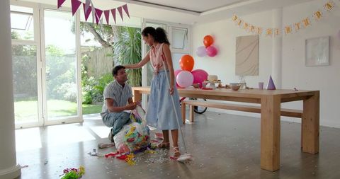 Couple Cleaning After Birthday Party in Bright Living Space
