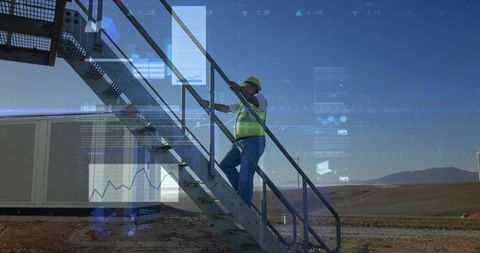 Engineer climbs wind farm stairs with data graphics overlay