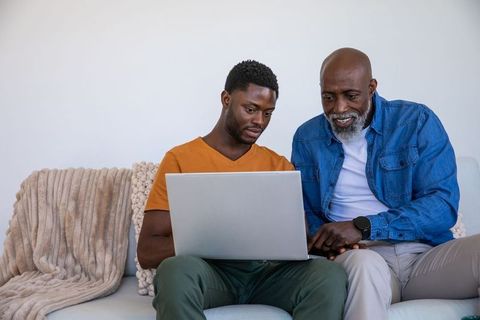 Father and Son Bonding Over Technology on Sofa