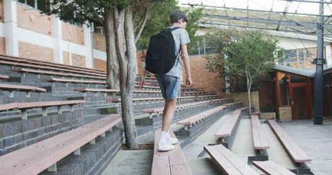 Teenage student balancing on wooden grandstand at school