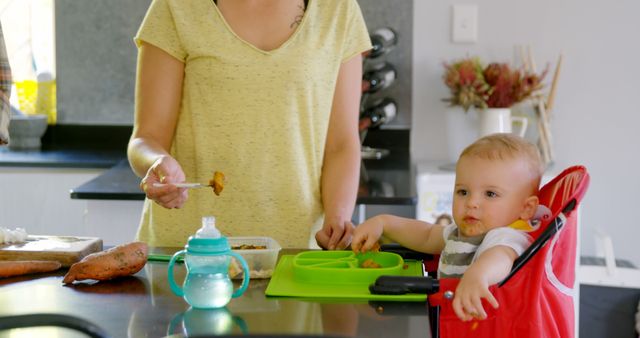 Mother Feeding Baby at Home Kitchen Table - Download Free Stock Images Pikwizard.com