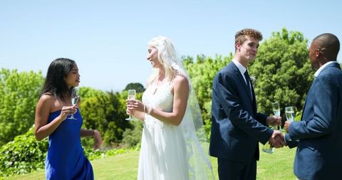 Joyful Bride and Groom with Multiracial Friends at Outdoor Wedding