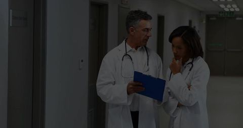 Doctors Reviewing Patient Records in Hospital Hallway