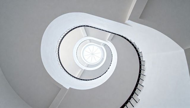 Minimalist White Spiral Staircase Rising to Circular Skylight, Architectural Geometry