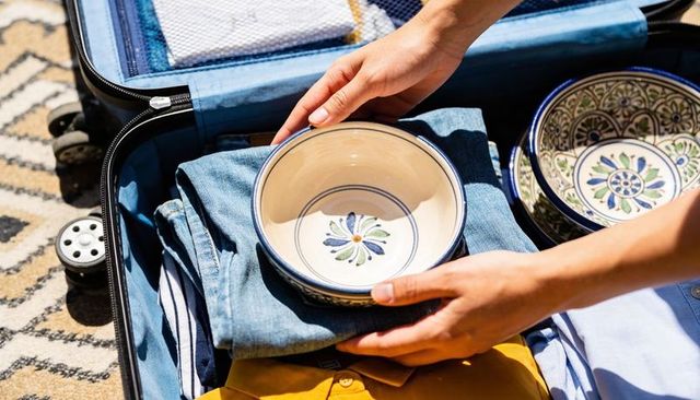 Packing fragile hand-painted ceramic bowls into suitcase for safe travel and home moving