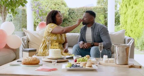 Couple Celebrating Special Occasion with Cake and Champagne Outdoors