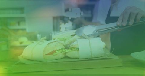 Chef arranging wrapped gourmet sandwiches on rustic café counter