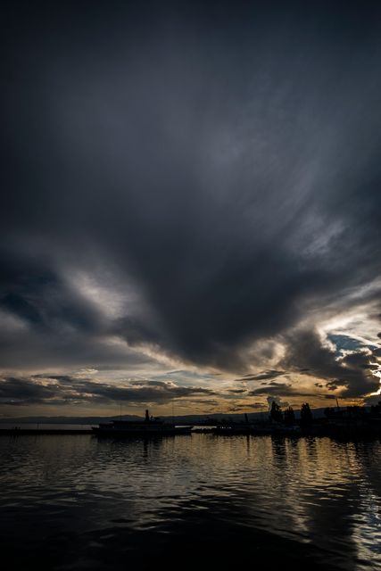 Dramatic Sunset with Dark Clouds Over Lake - Download Free Stock Photos Pikwizard.com