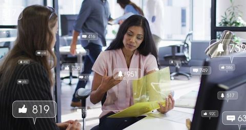 Holding yellow folder and discussing work with colleague amid social media notifications