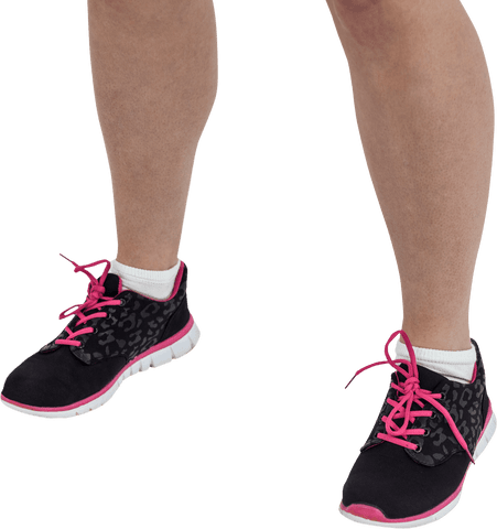 Low section of person wearing black sneakers with pink accents on transparent