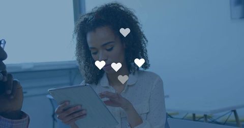Young professional tapping tablet coworking space with heart overlay for social engagement