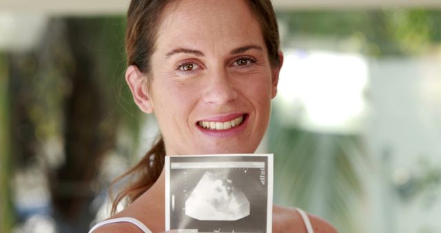 Smiling Pregnant Woman Holding Ultrasound Photo - Download Free Stock Images Pikwizard.com