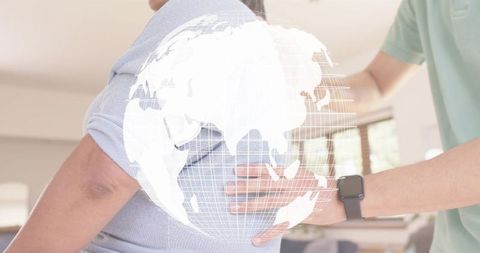 Caregiver helping senior woman at home with holographic globe visualizing health data