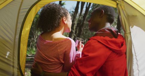 Diverse Couple Relaxing in Tent Enjoying Nature
