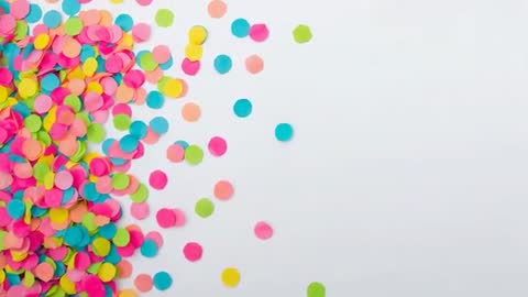Vibrant confetti spilling and scattering across white background with wide copy space