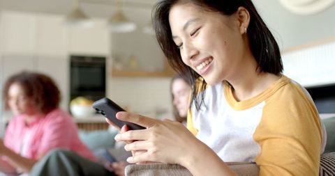 Young woman engaging with smartphone in cozy apartment