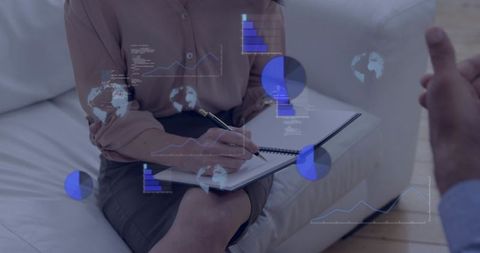 Consultant taking notes during client meeting with augmented reality data overlays