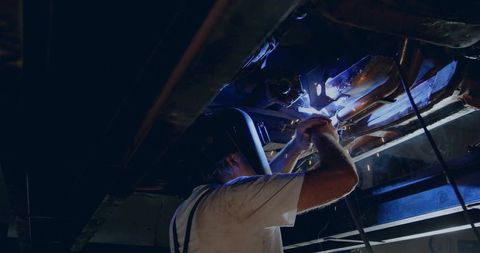 Welding Technician Illuminates Metalwork in Industrial Setting